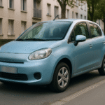 Voiture citadine électrique compacte branchée à une borne murale domestique